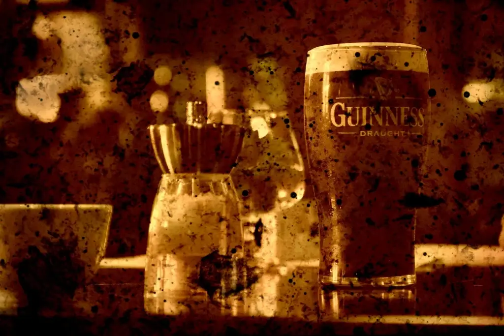Guinness-Glas und Streuer vor unscharfen Lichtern, stark in Braun und Rot gefärbt und mit Flecken überzogen