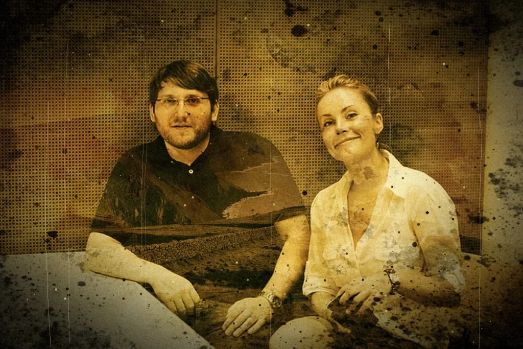 Ein Mann mit Brille und eine Frau sitzen nebeneinander vor einer gelochten Wand. Das Bild ist bernsteinfarben getönt und mit Flecken und Kratzern überzogen, in das schwarze Hemd des Mannes scheint eine neblige Küstenlandschaft hinein.